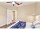 Bright bedroom with a ceiling fan and view to an en-suite bathroom through a hall with wood floors at 20254 Ravens End Dr, Tampa, FL 33647