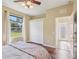 Bedroom with wood floors, ceiling fan and double door closet, with views to green space outside at 20254 Ravens End Dr, Tampa, FL 33647