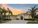 Charming home with a well-manicured lawn and a two-car garage, all set against a colorful sunset at 20254 Ravens End Dr, Tampa, FL 33647