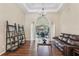 Open living room area featuring hardwood floors, coffered ceiling, pillars, chandelier and access to the screened-in patio at 20254 Ravens End Dr, Tampa, FL 33647