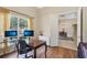 Home office featuring wood floors, a desk, and a view of the dining room, seamlessly blending work and living spaces at 20254 Ravens End Dr, Tampa, FL 33647