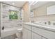 Bathroom with a double sink vanity, decorative subway tiles, and a shower with a window at 2042 Craft Ln, Sarasota, FL 34239