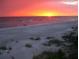 Sunset over a serene beach with colorful sky reflecting in the calm waters at 2042 Craft Ln, Sarasota, FL 34239