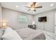 Relaxing bedroom with a ceiling fan, desk, chair, TV, and large window providing natural light at 2042 Craft Ln, Sarasota, FL 34239