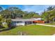 Charming single-story home with a manicured lawn, carport, and vibrant red accent wall at 2042 Craft Ln, Sarasota, FL 34239