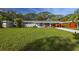 Charming single-story home with a well-kept lawn, covered carport, and vibrant red accent wall at 2042 Craft Ln, Sarasota, FL 34239