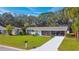 Well-maintained home with a spacious lawn, long driveway, and mature trees providing shade at 2042 Craft Ln, Sarasota, FL 34239