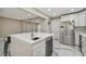 Modern kitchen island with stainless steel appliances and white marble flooring at 2042 Craft Ln, Sarasota, FL 34239
