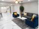 Open living room with modern gray sofa, blue armchairs, and stylish marble floors at 2042 Craft Ln, Sarasota, FL 34239