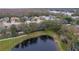 Aerial view of a home situated on a pond, with tree coverage and pristine landscaping throughout the community at 21215 Tyrell Way, Land O Lakes, FL 34638