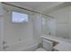 Bright bathroom with a shower-tub combo, white tile surround and a window at 21215 Tyrell Way, Land O Lakes, FL 34638