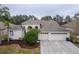Charming home featuring a three-car garage, arched entrance, and well-maintained landscaping at 21215 Tyrell Way, Land O Lakes, FL 34638