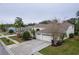Exterior view of home with lush landscaping, a three-car garage, and inviting curb appeal at 21215 Tyrell Way, Land O Lakes, FL 34638