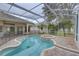 Enclosed swimming pool and hot tub with screened enclosure and brick patio at 21215 Tyrell Way, Land O Lakes, FL 34638