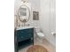 Stylish powder room with a blue vanity, marble countertop, and decorative mirror, creating a fresh look at 214 S Audubon Ave, Tampa, FL 33609