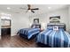 Well-lit bedroom with ceiling fan showcases two beds and en-suite bathroom at 214 S Audubon Ave, Tampa, FL 33609
