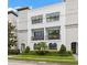Modern townhome boasts clean lines, balconies, a manicured lawn, and lush shrubbery at 214 S Audubon Ave, Tampa, FL 33609