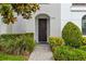 Charming entryway with a dark wood front door, stone pathway, and lush landscaping creates a warm welcome at 214 S Audubon Ave, Tampa, FL 33609