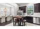 A modern kitchen featuring stainless steel appliances, dark wood cabinets, and a breakfast table at 214 S Audubon Ave, Tampa, FL 33609