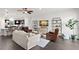 Open-concept living room with a kitchen view, hardwood floors, and comfortable seating arrangement at 214 S Audubon Ave, Tampa, FL 33609