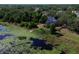 Lakeside property featuring a private dock and lush landscaping, captured in a scenic aerial shot at 219 Galaxy Ave, Spring Hill, FL 34606