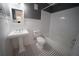 Well-lit bathroom featuring black and white tiled floors and a modern pedestal sink at 219 Galaxy Ave, Spring Hill, FL 34606