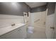 Well-lit bathroom features a white vanity, toilet, shower, and black and white tile flooring at 219 Galaxy Ave, Spring Hill, FL 34606