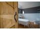 Bright bathroom boasts a clawfoot tub, pedestal sink, gray walls, and wood-look flooring at 219 Galaxy Ave, Spring Hill, FL 34606