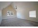 A large bedroom with carpet floors has two windows, neutral colored walls, and a hanging chandelier at 219 Galaxy Ave, Spring Hill, FL 34606