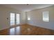 Spacious living room featuring hardwood floors, wainscoting, and bright glass doors at 219 Galaxy Ave, Spring Hill, FL 34606
