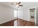 This bedroom features wood floors, two closets, a window and a ceiling fan with a light at 2203 Malaga Ave, Spring Hill, FL 34609