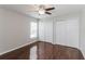 This bedroom features wood floors, two closets, a window and a ceiling fan with a light at 2203 Malaga Ave, Spring Hill, FL 34609