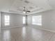 Spacious bedroom featuring tile floors, a tray ceiling with fan, and ample natural light at 2203 Malaga Ave, Spring Hill, FL 34609
