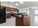 Open kitchen with granite countertops, stainless steel appliances, island, and tile floors at 2203 Malaga Ave, Spring Hill, FL 34609