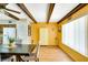 Cozy dining area with bright yellow walls, wood beams, and a large window for natural light at 2284 Philippine Dr # 7, Clearwater, FL 33763