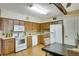 Functional kitchen with updated appliances, wood cabinets, and tiled backsplash and a large window at 2284 Philippine Dr # 7, Clearwater, FL 33763