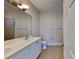 Bathroom featuring double sinks, tiled floors and shower, toilet, and good lighting at 2416 Caraway Dr, Venice, FL 34292