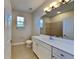 Bathroom featuring long vanity and good light, window and tiled flooring at 2416 Caraway Dr, Venice, FL 34292