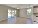 Open living room with tile flooring, sliding doors, and ample natural light adjacent to the kitchen at 2416 Caraway Dr, Venice, FL 34292
