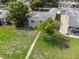 Single-story home with a well-maintained front lawn, cozy porch, and a mature shade tree in an aerial view at 2435 37Th N Ave, St Petersburg, FL 33713