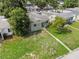 Charming single-story home with a well-maintained front lawn, cozy porch, and a mature shade tree in an aerial view at 2435 37Th N Ave, St Petersburg, FL 33713