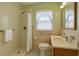 A cozy bathroom featuring a shower, toilet, and vanity with ample lighting and soft color tones at 2435 37Th N Ave, St Petersburg, FL 33713