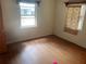 Simple bedroom with hardwood floors, windows, and minimal furnishings offering potential for customization at 2435 37Th N Ave, St Petersburg, FL 33713
