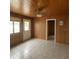 Bonus room with wood paneling, ceiling fan, neutral tile floor, and natural light from the window at 2435 37Th N Ave, St Petersburg, FL 33713