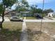 Street view of a light blue single-story home with a walkway, green grass, and parked cars at 2435 37Th N Ave, St Petersburg, FL 33713