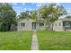 Charming single-story home featuring a cozy front porch and a well-maintained lawn and landscaped yard at 2435 37Th N Ave, St Petersburg, FL 33713