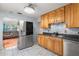 Bright kitchen featuring wood cabinets, stainless appliances, and a view into the adjacent living room at 2435 37Th N Ave, St Petersburg, FL 33713