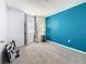 A vacant bedroom featuring an accent wall, large window, and neutral carpeting at 2530 Sandy Beach Ln, Clearwater, FL 33763