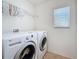 A tidy laundry room featuring a large capacity washer and dryer and storage shelf at 2530 Sandy Beach Ln, Clearwater, FL 33763