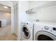 Efficient laundry room with full-size washer/dryer and overhead storage at 2530 Sandy Beach Ln, Clearwater, FL 33763